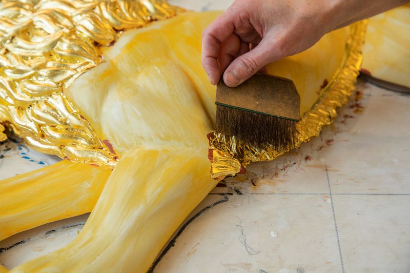 Stortingsløven fra 1866 er skåret i tre og forgylles med bladgull. Foto: Stortinget.