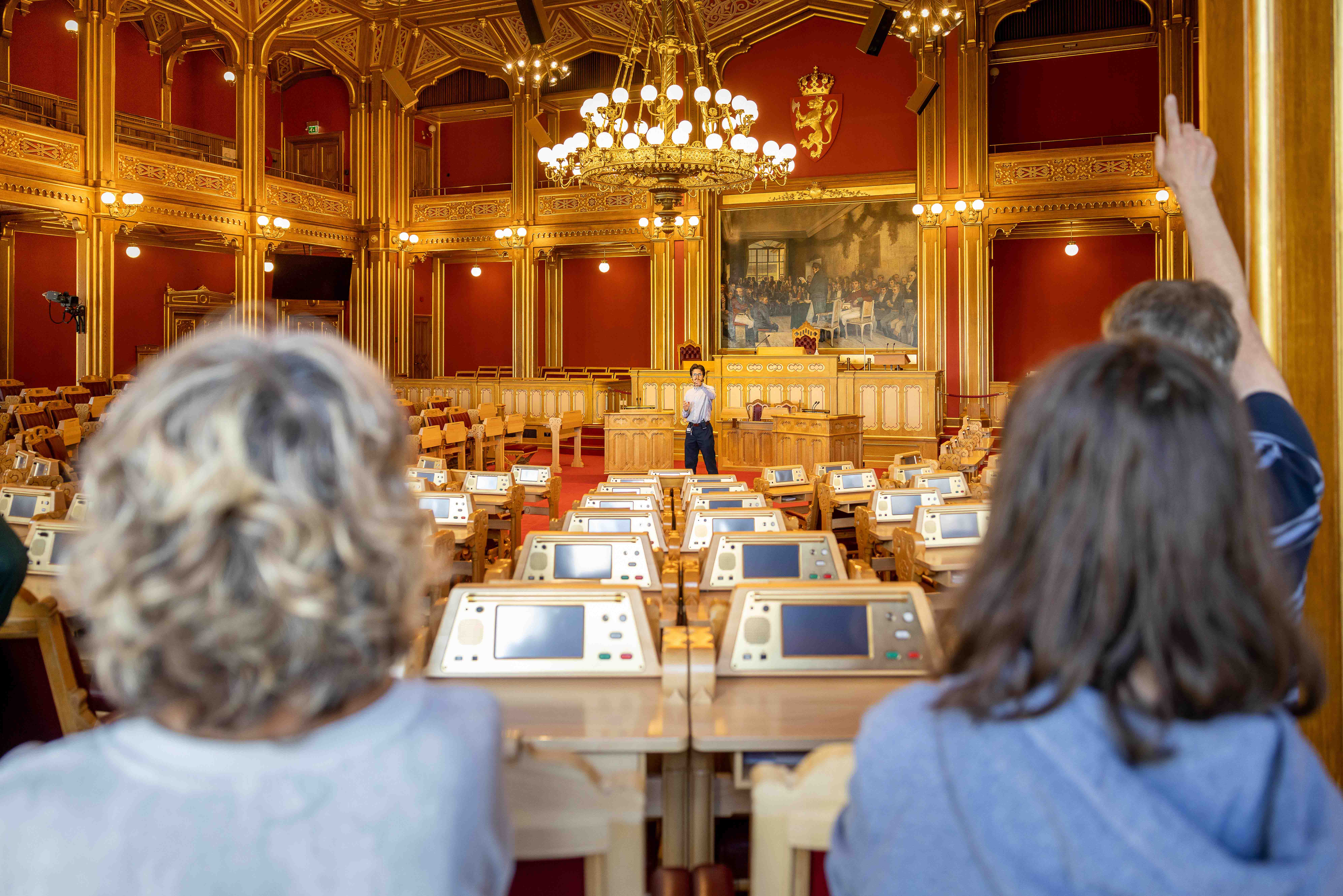 En gruppe mennesker står i trappehallen i stortingsbygningen.