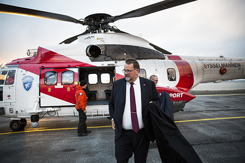 Komitéleder Svein Harberg (H) på vei ut av helikopteret som har landet i Longyearbyen, etter et besøk i den russiske gruvebyen Barentsburg. Et besøk gjort i forbindelse med familie- og kulturkomiteens reise til Svalbard i 2016. Foto: Stortinget.