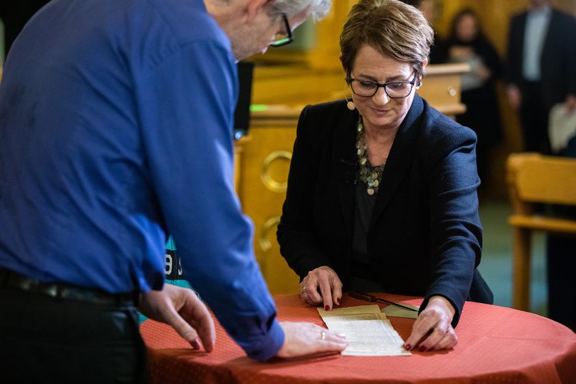 Stortingspresident Tone Wilhelmsen Trøen åpner den 103 år gamle stemmeseddelen fra Karoline Emilie Larsen.
