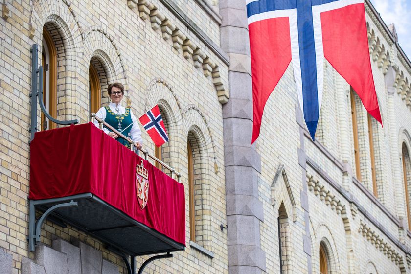 I tillegg til flagget som ble vedtatt i 1821 og som pryder stortingsbalkongen 17. mai, viser stortingspresident Tone Wilhelmsen Trøen frem de andre originale flaggforslagene fra  den 17. mai. Foto: Stortinget.
