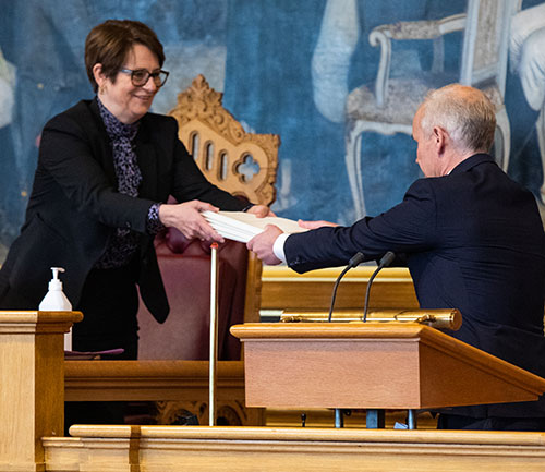 Finansminister Jan Tore Sanner overrekker forslaget til revidert nasjonalbudsjett for 2020 til stortingspresident Tone W. Trøen. Foto: Stortinget.