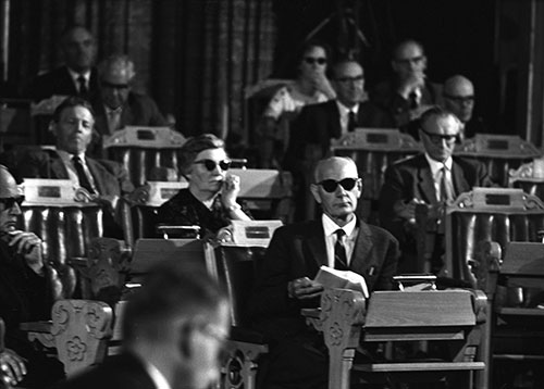 Under Kings-Bay-debatten i 1963 var det mange av representantene som brukte solbriller for å beskytte seg mot det sterke lyset fra lampene til NRK Fjernsynet. Bak statsminister Einar Gerhardsen (A) sitter Liv Tomter (A) fra Akershus. Foto: Aage Storløkken/NTB Scanpix.