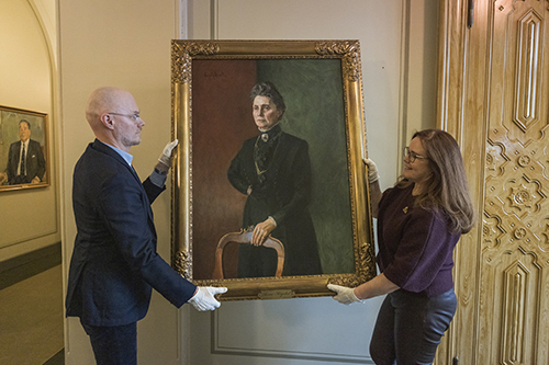 Eivind Torkjelsson and Christine Rahn from the Storting’s administration moving the portrait of Anna Rogstad from the Central Hall to the Eidsvoll Gallery.