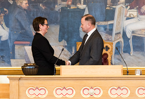 Olemic Thommessen overrekker presidentklubben til den nye stortingspresidenten Tone W. Trøen. Foto: Stortinget.