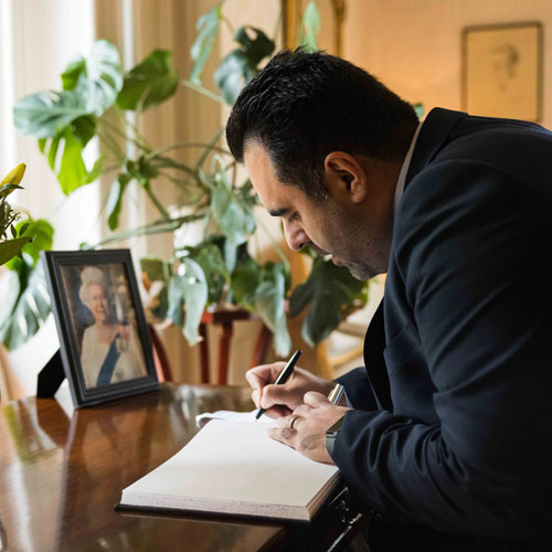The President of the Storting Masud Gharahkhani signing the book of condolence for Queen Elizabeth II. Photo: Storting.