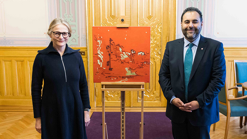 Kunstneren Astrid Nondal og stortingspresident Masud Gharahkhani ved siden av gaven, kunstverket Missing color. Foto: Stortinget.